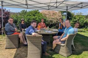 A group of people sitting around an outdoor table