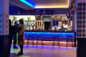 Photo of people standing in a bar with blue lighting