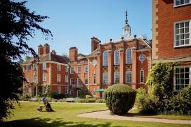 A view from the LMH gardens on an imposing red brick building with a white spire
