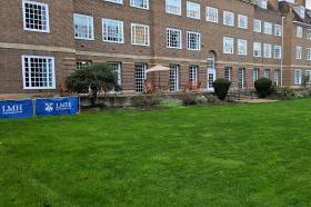 A long brick building with grass in front of it