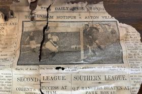 A clipping from a newspaper from 1910, which is discoloured from age. An image features footballers playing a match