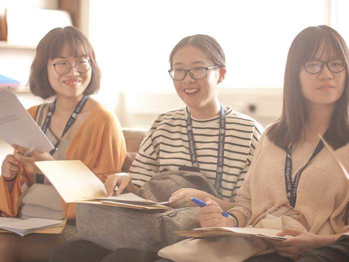 Three summer programme students smiling