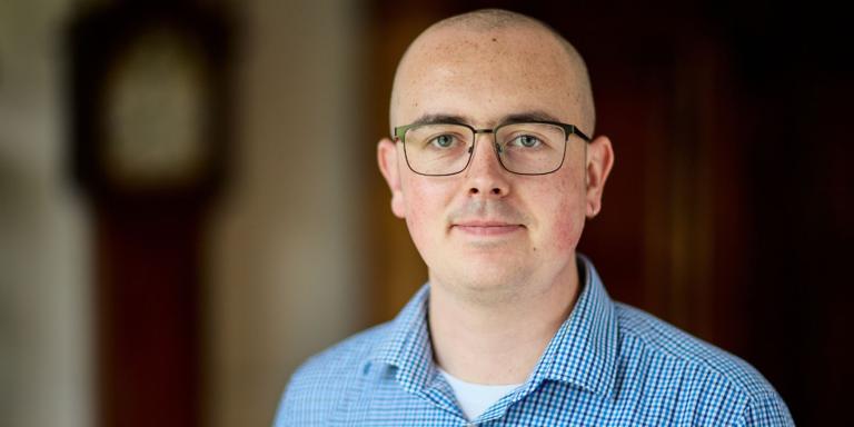 Samuel Johnson, a man wearing glasses and a blue shirt