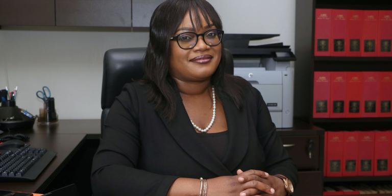 Dr Alicia Elias-Roberts sitting at her desk in her office at the University of the West Indies, St Augustine Campus