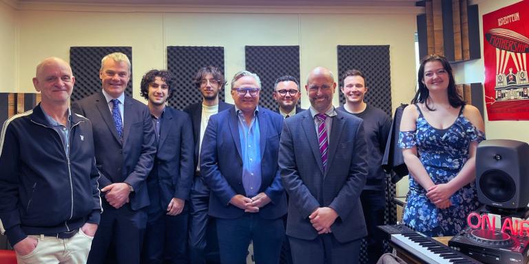 A photo of a group of people standing in a music recording studio in Lady Margaret Hall