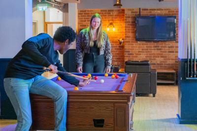 Two students playing pool in the LMH Bar