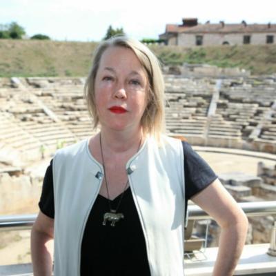 Photo of A.E. Stallings standing in front of a ruined ampitheatre