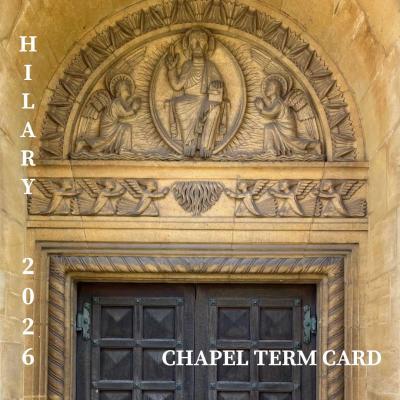 A photo of some stonework above a set of wooden double doors which depicts Jesus flanked by two kneeling angels