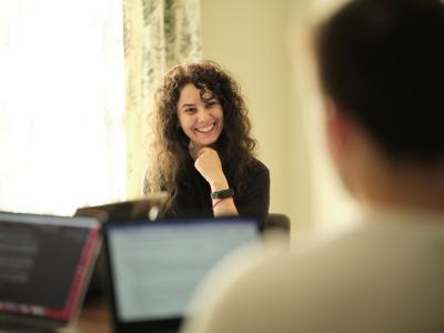 A tutor looks happily towards a student during a class.