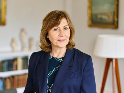 Professor Christine Gerrard wearing a navy suit standing in her office