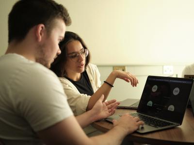 Two students looking at a screen in a class.