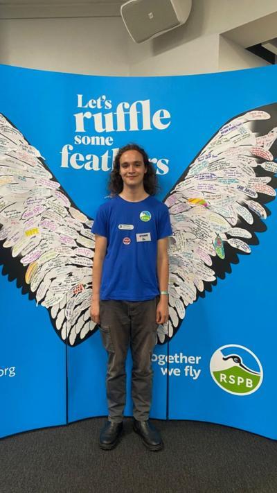 Freddie stood in front of a RSPB board