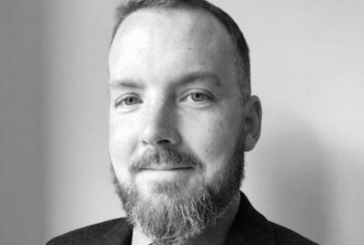 Black and white headshot of Dr David Campbell, who has short dark hear and a beard
