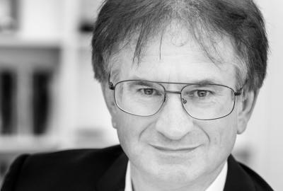 Black and white close-up of Professor Todd Huffman, who has short dark hair and wire-framed glasses