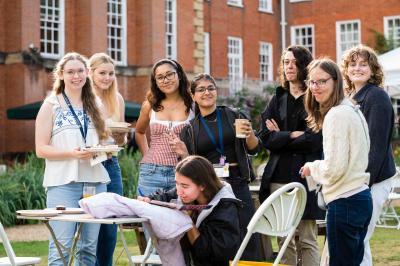 A group of students smile and look to camera in the college gardens