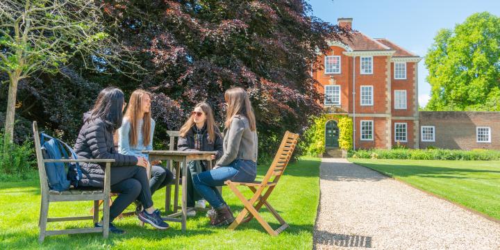 LMH students sitting at a table chatting in LMH grounds